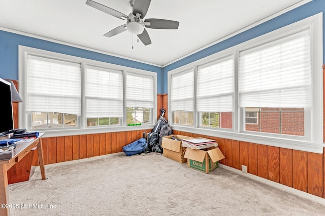 rec room with wooden walls, light colored carpet, and ceiling fan