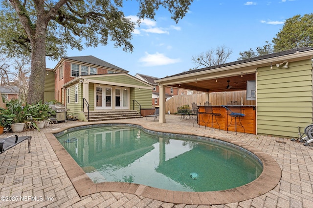 view of pool featuring a patio, a grill, an outdoor bar, and ceiling fan