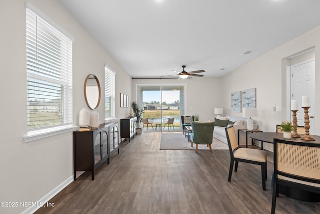 living room featuring ceiling fan and dark hardwood / wood-style flooring