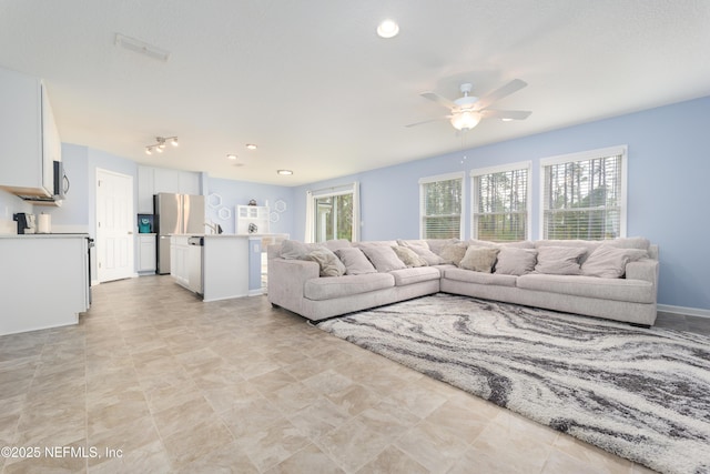 living room with ceiling fan and a wealth of natural light