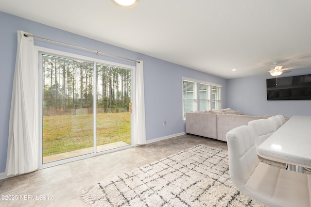 unfurnished living room featuring ceiling fan and plenty of natural light