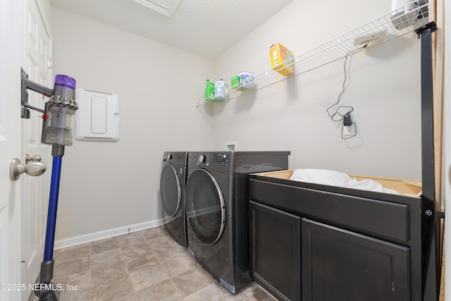 washroom with washer and dryer, cabinets, and a textured ceiling