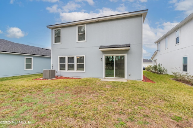 back of property featuring central AC unit and a yard