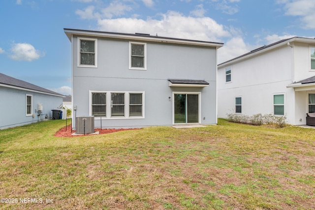 rear view of house with a yard and central AC unit