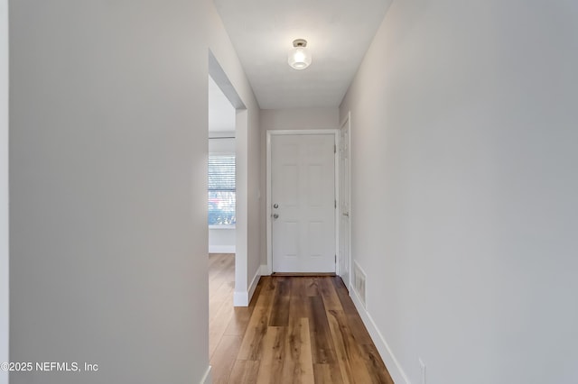 corridor with hardwood / wood-style flooring