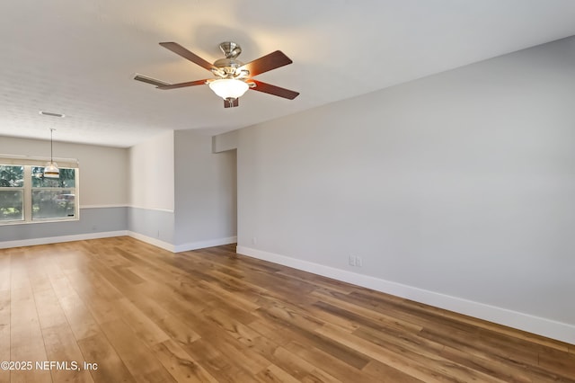 empty room featuring hardwood / wood-style flooring and ceiling fan