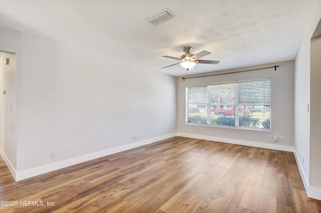 empty room with ceiling fan and light hardwood / wood-style flooring