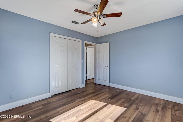 unfurnished bedroom featuring dark wood-type flooring, ceiling fan, and a closet