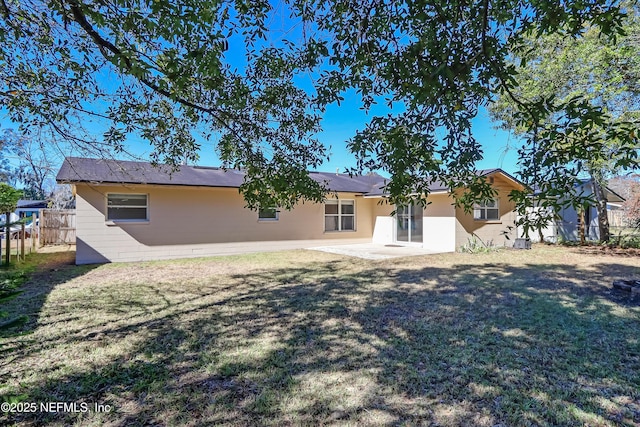 back of house with a patio area and a yard