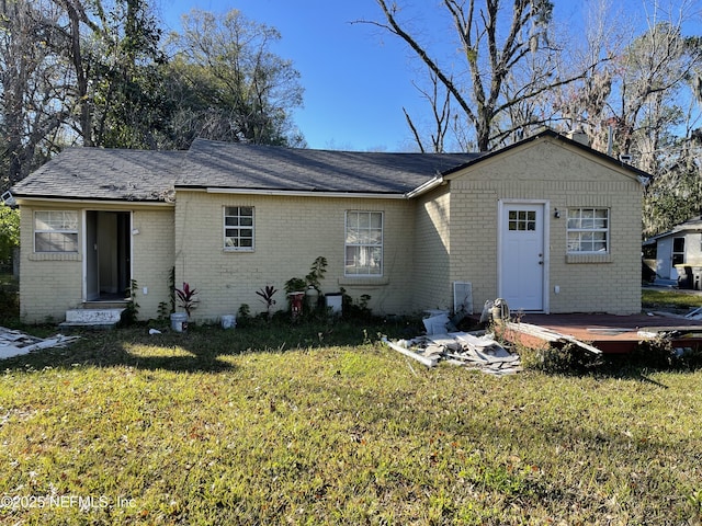 back of property with a lawn and a wooden deck