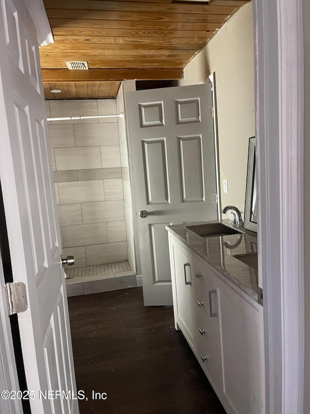 interior space with dark hardwood / wood-style flooring, wooden ceiling, and sink