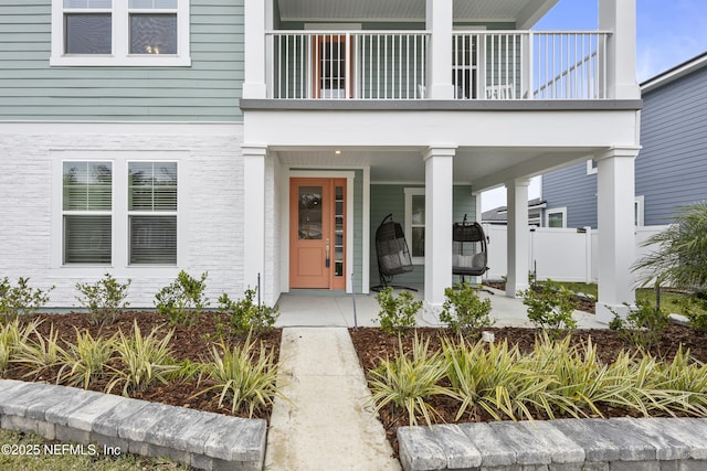 property entrance with covered porch and a balcony