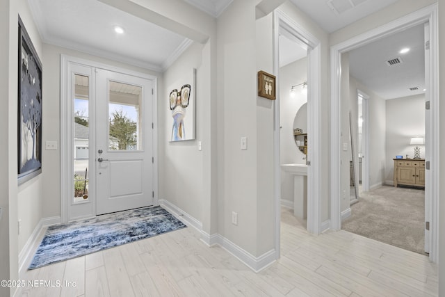 entrance foyer featuring light wood-type flooring and ornamental molding