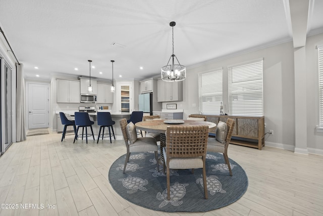 dining space with light wood-type flooring and crown molding