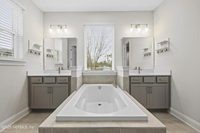 bathroom with plenty of natural light, a relaxing tiled tub, and tile patterned flooring