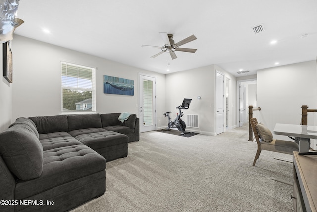 carpeted living room with ceiling fan