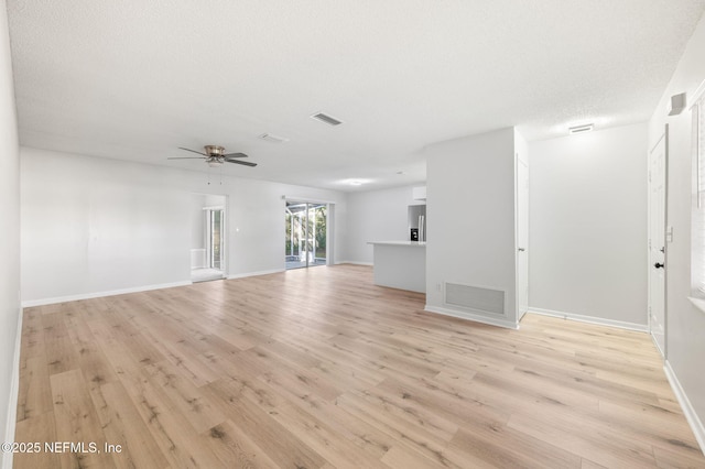 unfurnished living room featuring a textured ceiling, ceiling fan, and light hardwood / wood-style floors