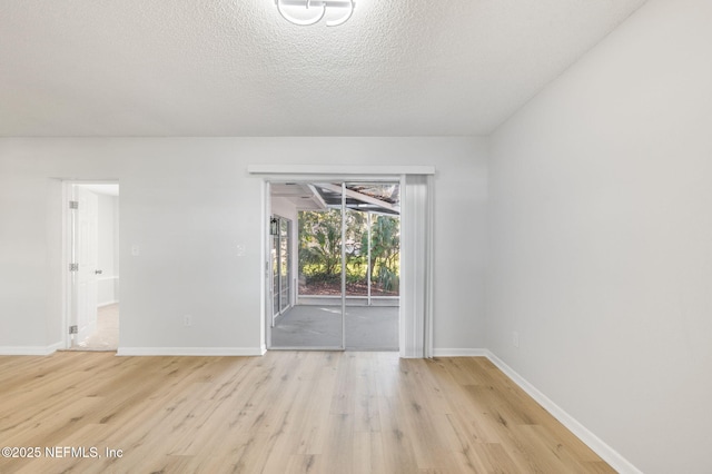 spare room featuring a textured ceiling and light hardwood / wood-style flooring