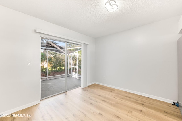 empty room featuring a textured ceiling and light wood-type flooring