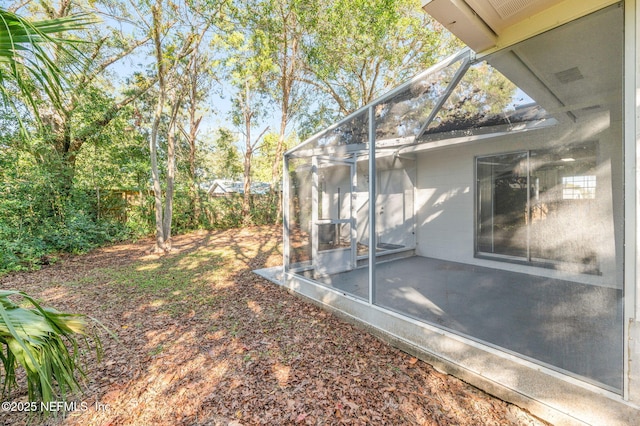 view of yard with a patio and glass enclosure