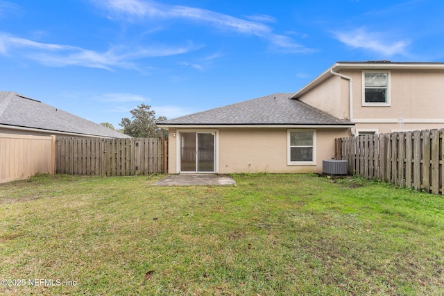 rear view of property featuring stucco siding, a yard, and central AC unit