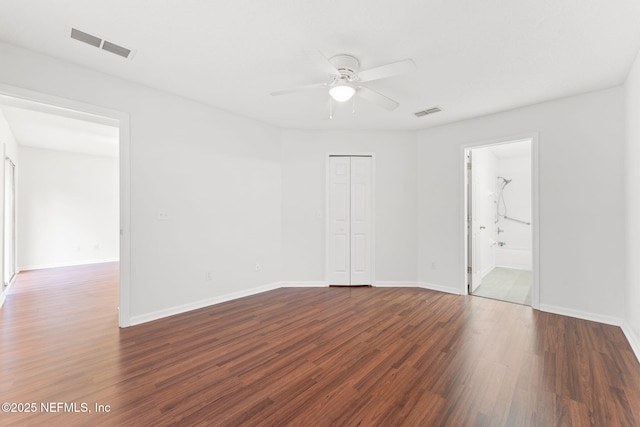 unfurnished bedroom featuring dark wood-style flooring, visible vents, and baseboards