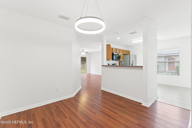 interior space featuring dark wood-style floors, visible vents, and baseboards