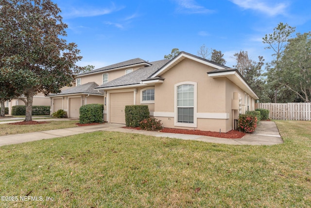 view of front of house with stucco siding, fence, a garage, driveway, and a front lawn