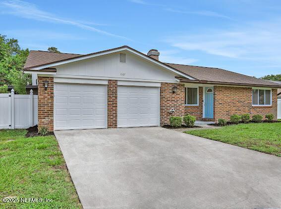 ranch-style home with a front lawn and a garage