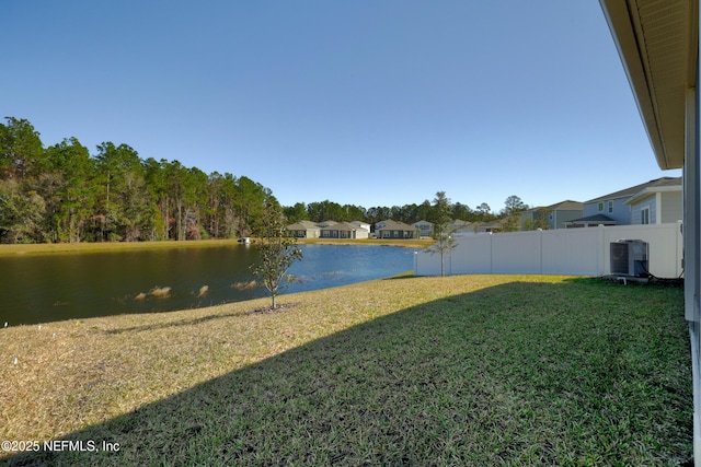 view of yard with central AC unit and a water view