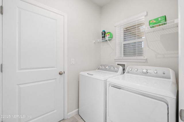 laundry area with independent washer and dryer and light tile patterned flooring