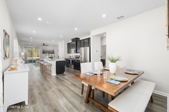 dining space with ceiling fan and light hardwood / wood-style floors