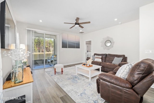 living room featuring light wood-type flooring and ceiling fan