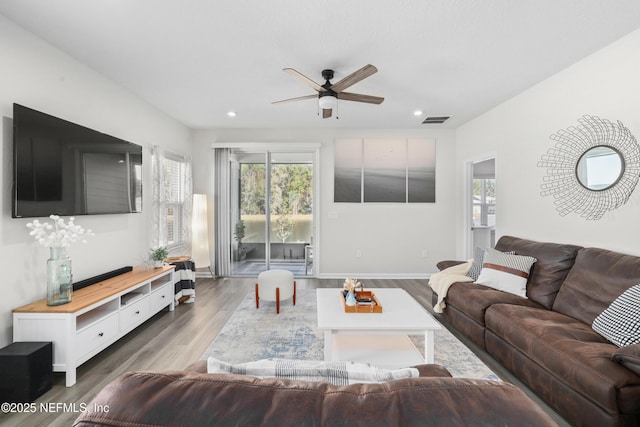 living room with hardwood / wood-style flooring and ceiling fan