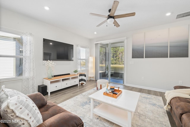 living room with light wood-type flooring and ceiling fan