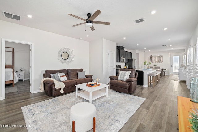 living room featuring ceiling fan and dark hardwood / wood-style flooring