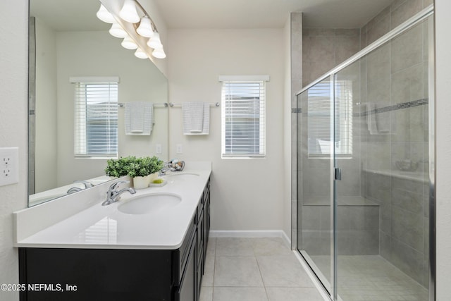 bathroom featuring a shower with shower door, vanity, and tile patterned flooring