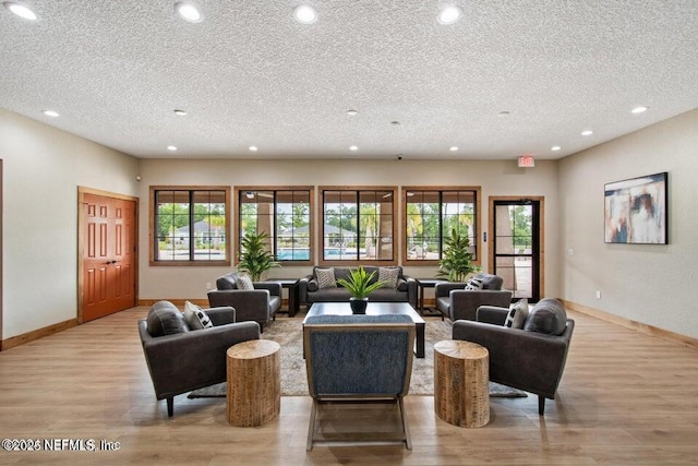 living room with a textured ceiling, a wealth of natural light, and light hardwood / wood-style flooring