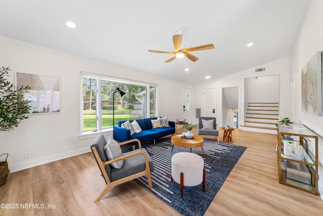 living room featuring light wood-type flooring, ceiling fan, and vaulted ceiling