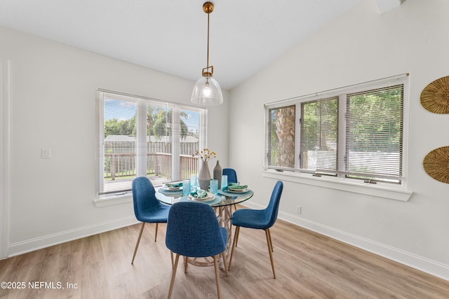 dining space featuring light hardwood / wood-style floors and lofted ceiling