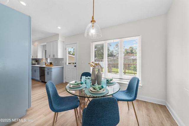 dining area with sink and light hardwood / wood-style flooring