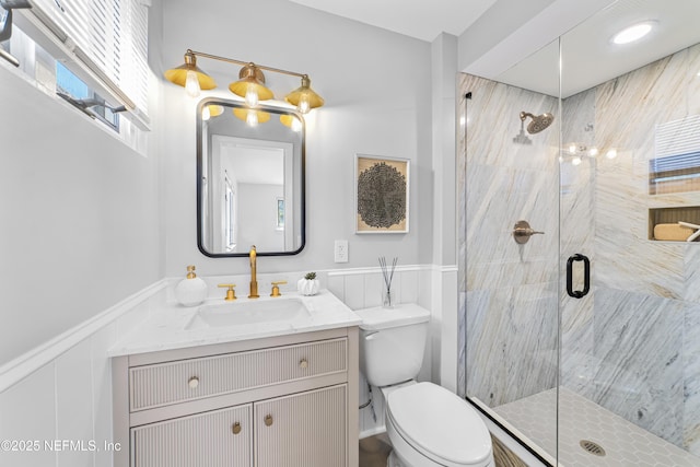 bathroom featuring walk in shower, plenty of natural light, vanity, and toilet