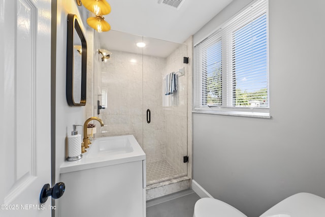 bathroom featuring a shower with door, vanity, and toilet