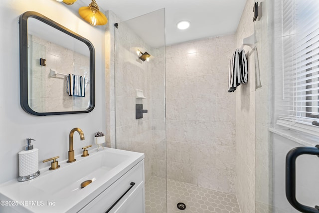 bathroom featuring a shower with door and vanity