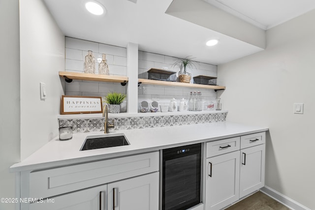 kitchen with dark hardwood / wood-style flooring, beverage cooler, tasteful backsplash, and sink