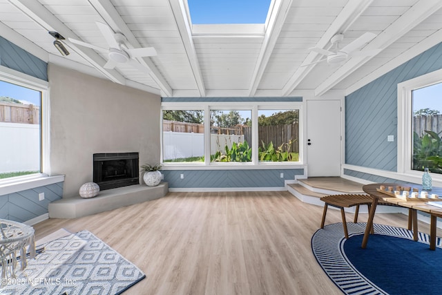 sunroom / solarium featuring a wealth of natural light, a skylight, and ceiling fan