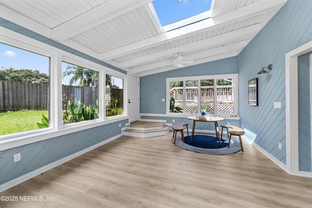 sunroom / solarium featuring ceiling fan and vaulted ceiling with skylight