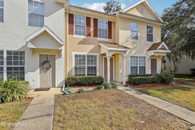 townhome / multi-family property featuring a front yard