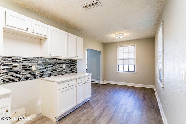 kitchen featuring tasteful backsplash, white cabinetry, a textured ceiling, and light hardwood / wood-style floors