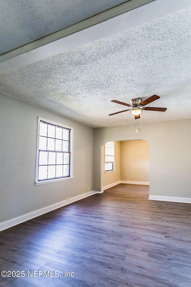 empty room with ceiling fan, a textured ceiling, and dark hardwood / wood-style flooring